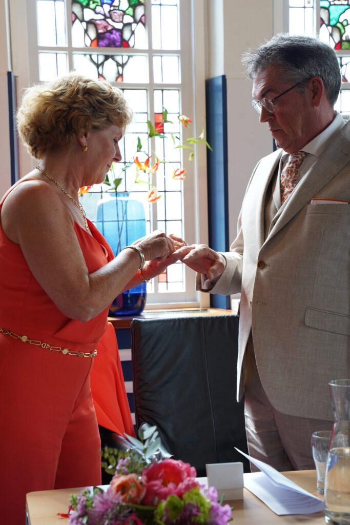 Bruid schuift de trouwring om bij de bruidegom tijdens de ceremonie in Rotterdam.