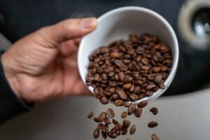 Productvideo laten maken – Mart Studio: koffiebonen worden in de koffiebrander gegoten bij Lorando & Morini.