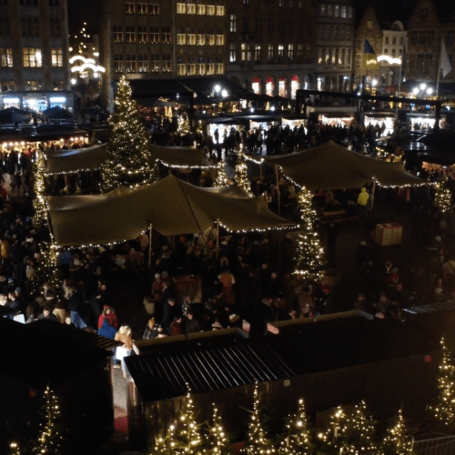 Avondbeeld van de kerstmarkt in Brugge met verlichte FOCO Barcontainers