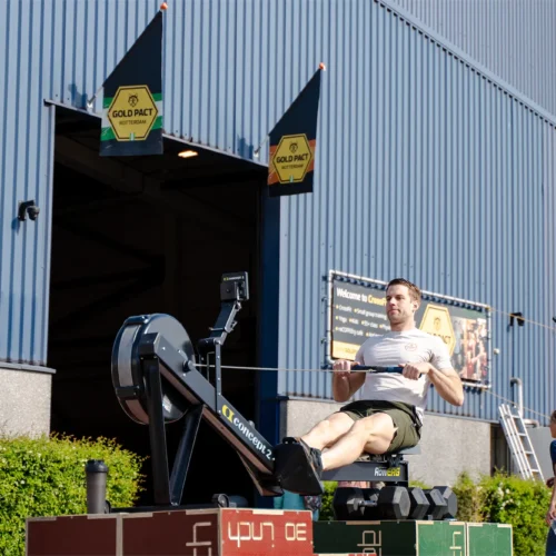 Man op een roeimachine voor de Gold Pact aanmoedigingsstage tijdens de marathon in Rotterdam.