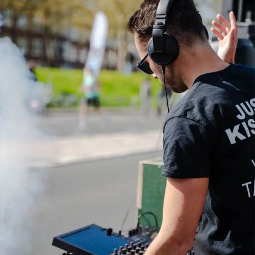 DJ met koptelefoon draait muziek bij de Gold Pact stage tijdens de marathon.
