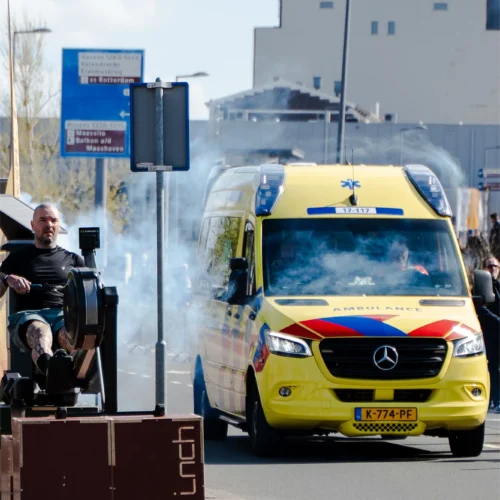 Ambulance rijdt langs de Gold Pact stage tijdens de marathon in Rotterdam.