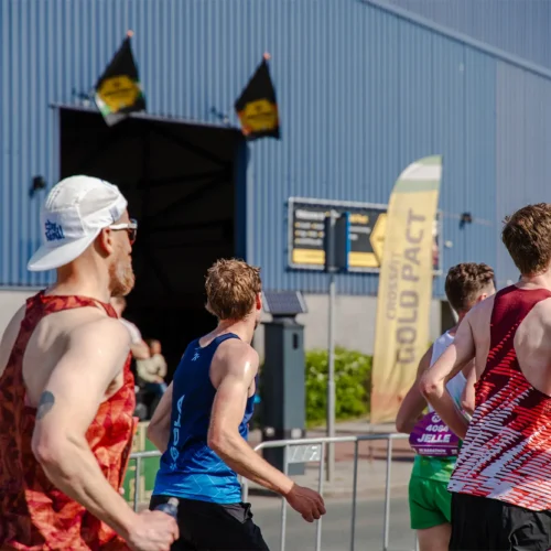 Marathonlopers rennen langs de Gold Pact aanmoedigingsstage tijdens de marathon.