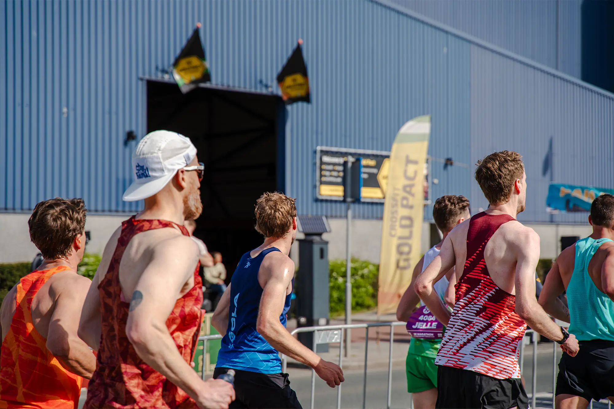 Marathonlopers rennen langs de Gold Pact aanmoedigingsstage tijdens de marathon.