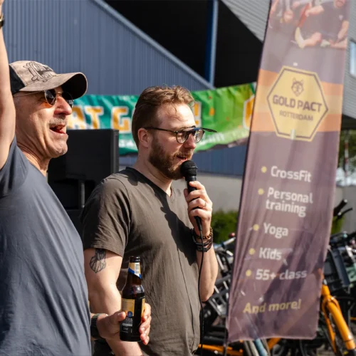 Presentator spreekt in microfoon bij de Gold Pact stage tijdens de marathon.