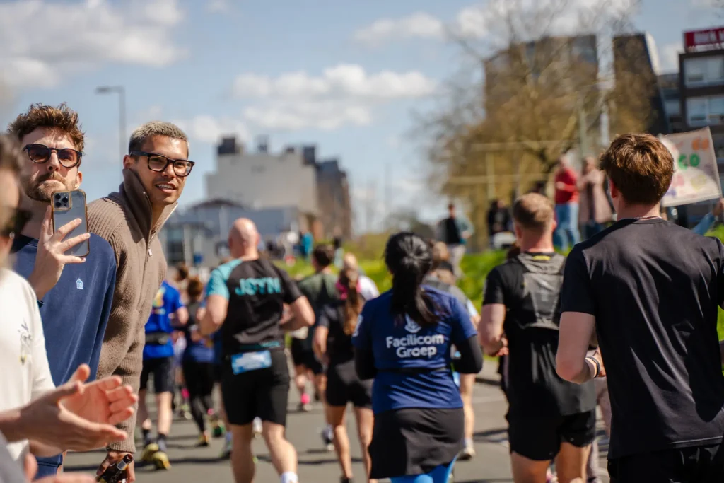 Supporters kijken en moedigen marathonlopers aan langs het parcours.