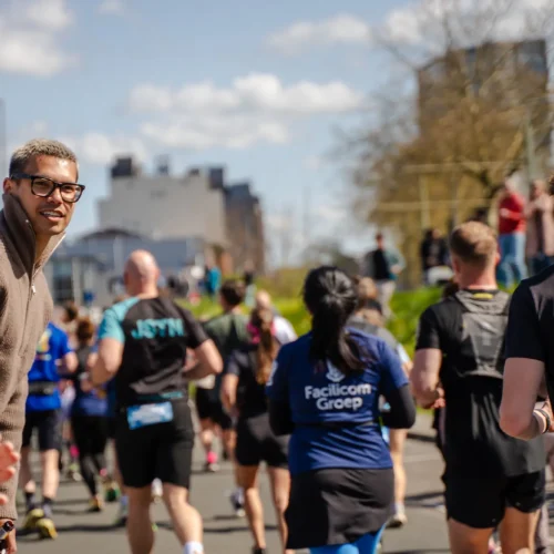 Supporters kijken en moedigen marathonlopers aan langs het parcours.