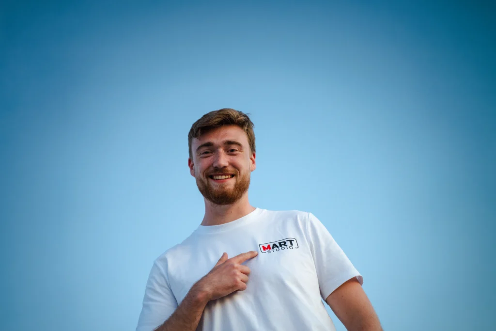 Portret van man met Mart Studio T-shirt en logo zichtbaar op borst