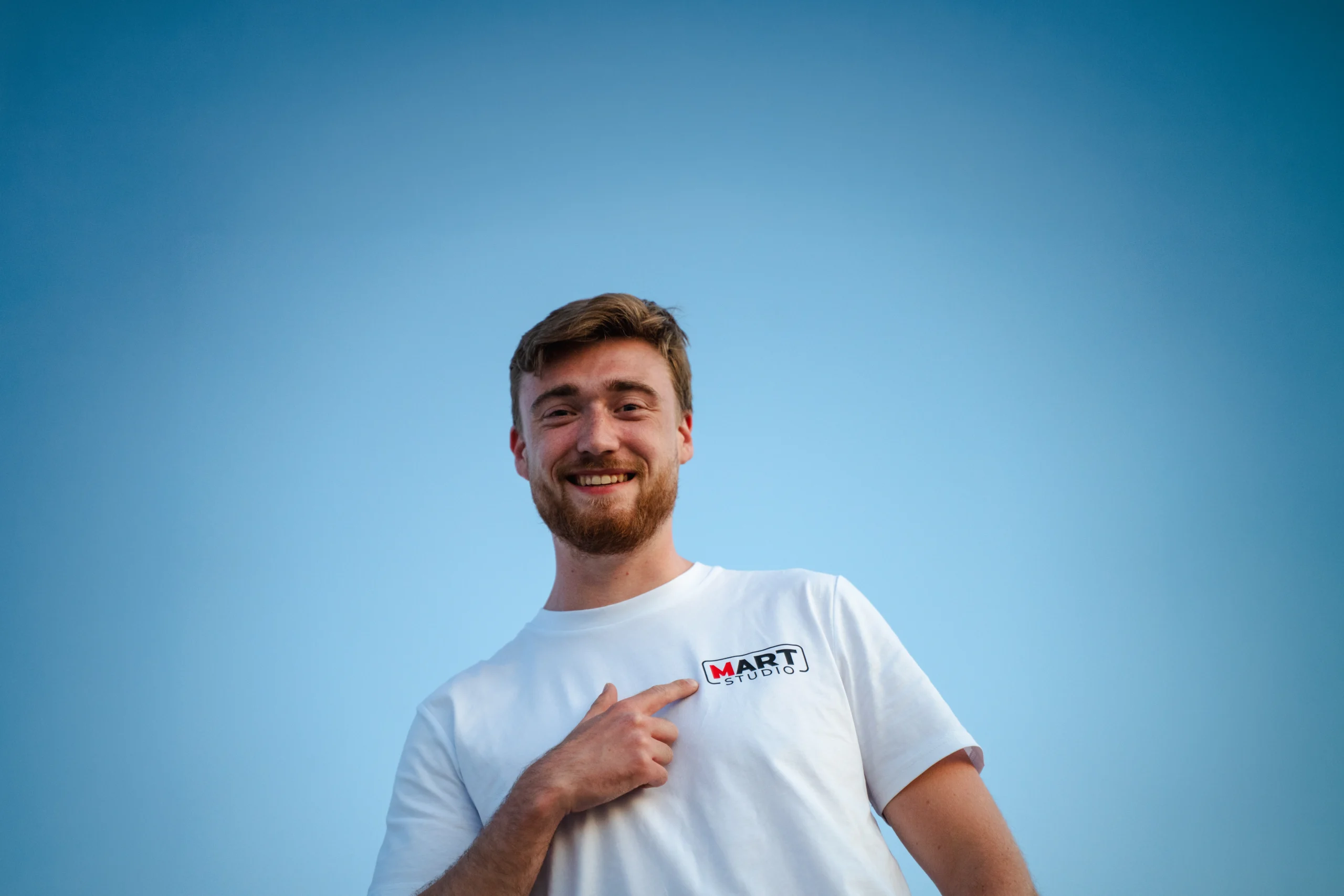 Portret van man met Mart Studio T-shirt en logo zichtbaar op borst