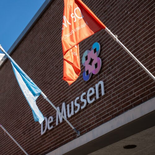 Vlaggen voor de gevel van buurtcentrum De Mussen tijdens het jubileumfeest.
