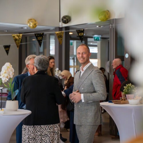 Bezoekers in gesprek tijdens de viering van 100 jaar De Mussen.