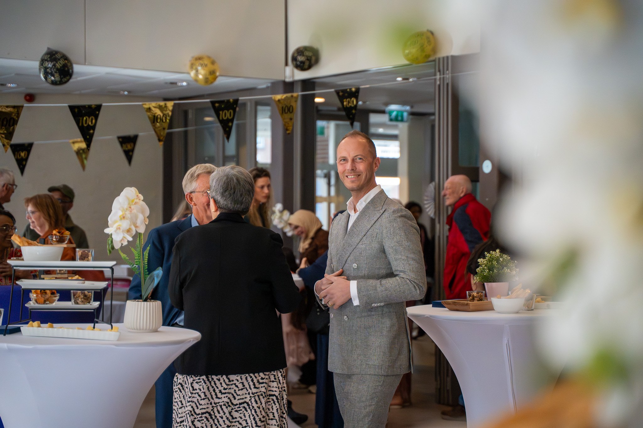 Bezoekers in gesprek tijdens de viering van 100 jaar De Mussen.