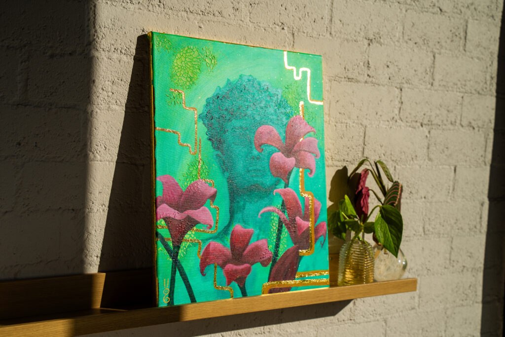 Handgemaakt groen schilderij met roze bloemen en gouden details van Studio Isobel op een houten wandplank.