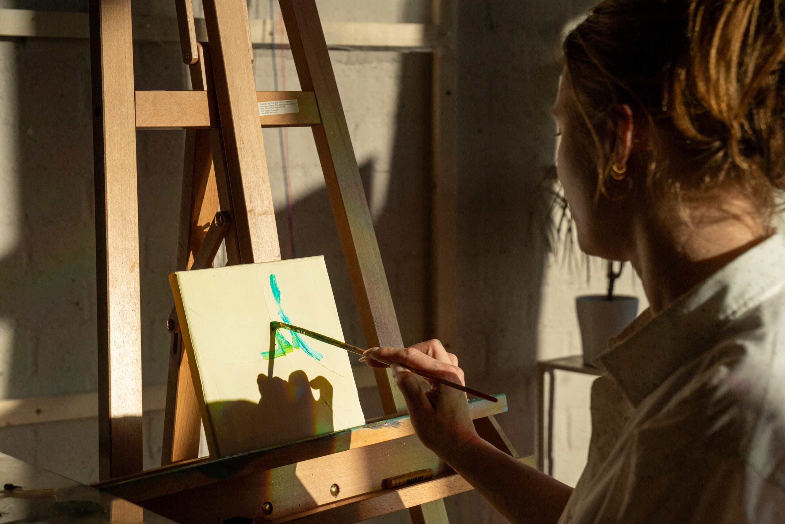 Kunstenaar schildert een nieuw kunstwerk op een ezel in het atelier van Studio Isobel.