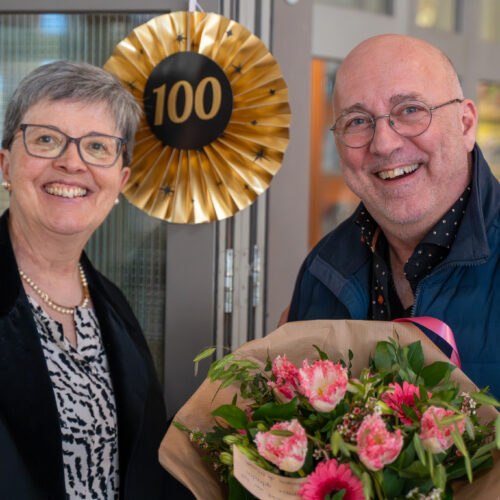 Bezoekers poseren met feestelijke attributen tijdens het 100-jarig jubileum van De Mussen.