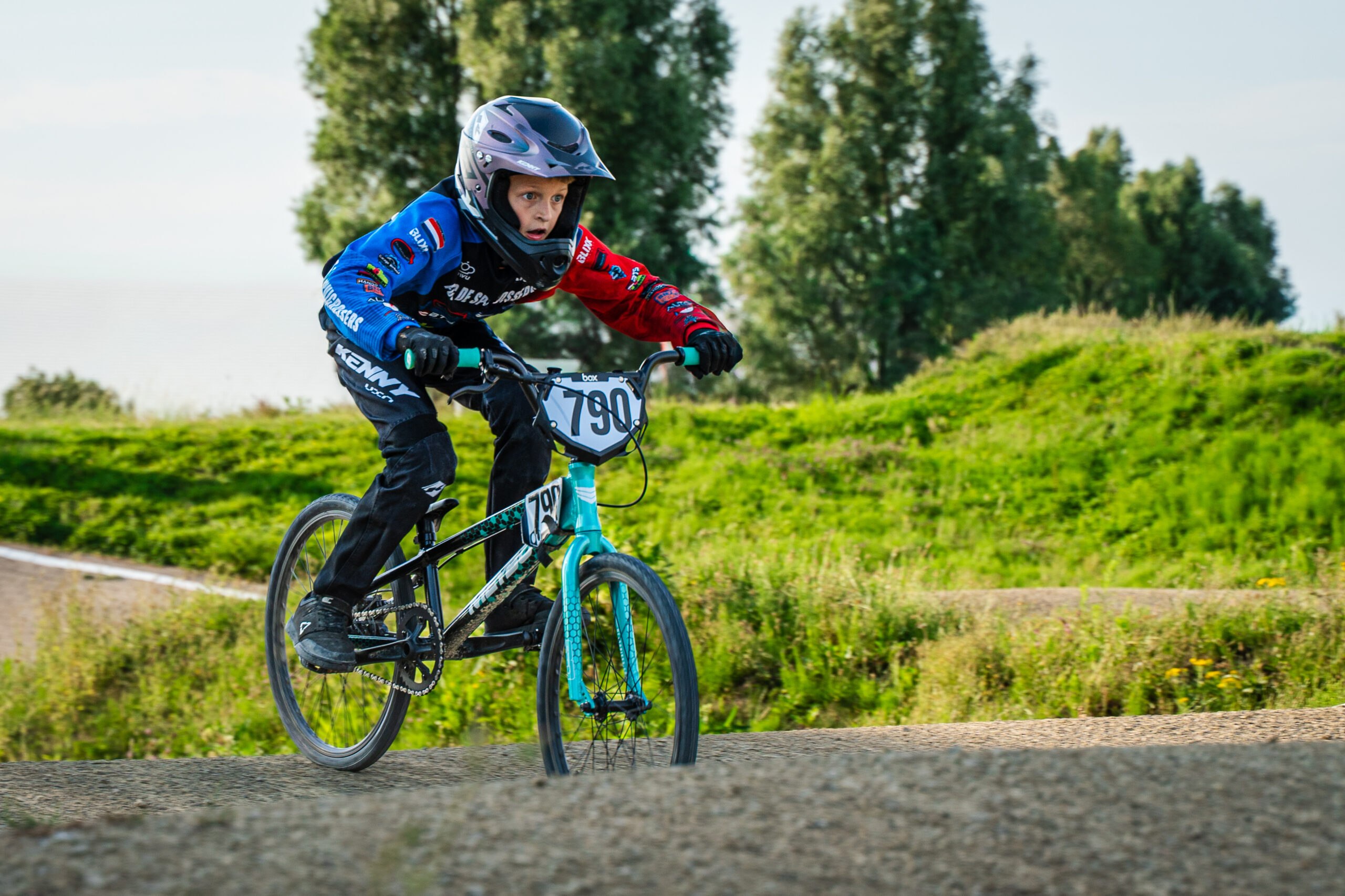 Jonge BMX-rijder vliegt over een heuvel tijdens de wedstrijd bij Fietscross Club Barendrecht.