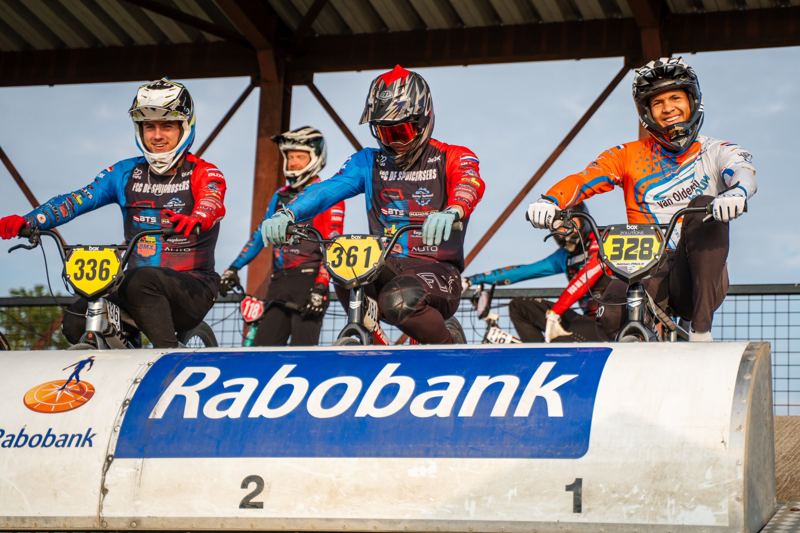 BMX-rijders staan klaar achter het starthek voor de volgende race.