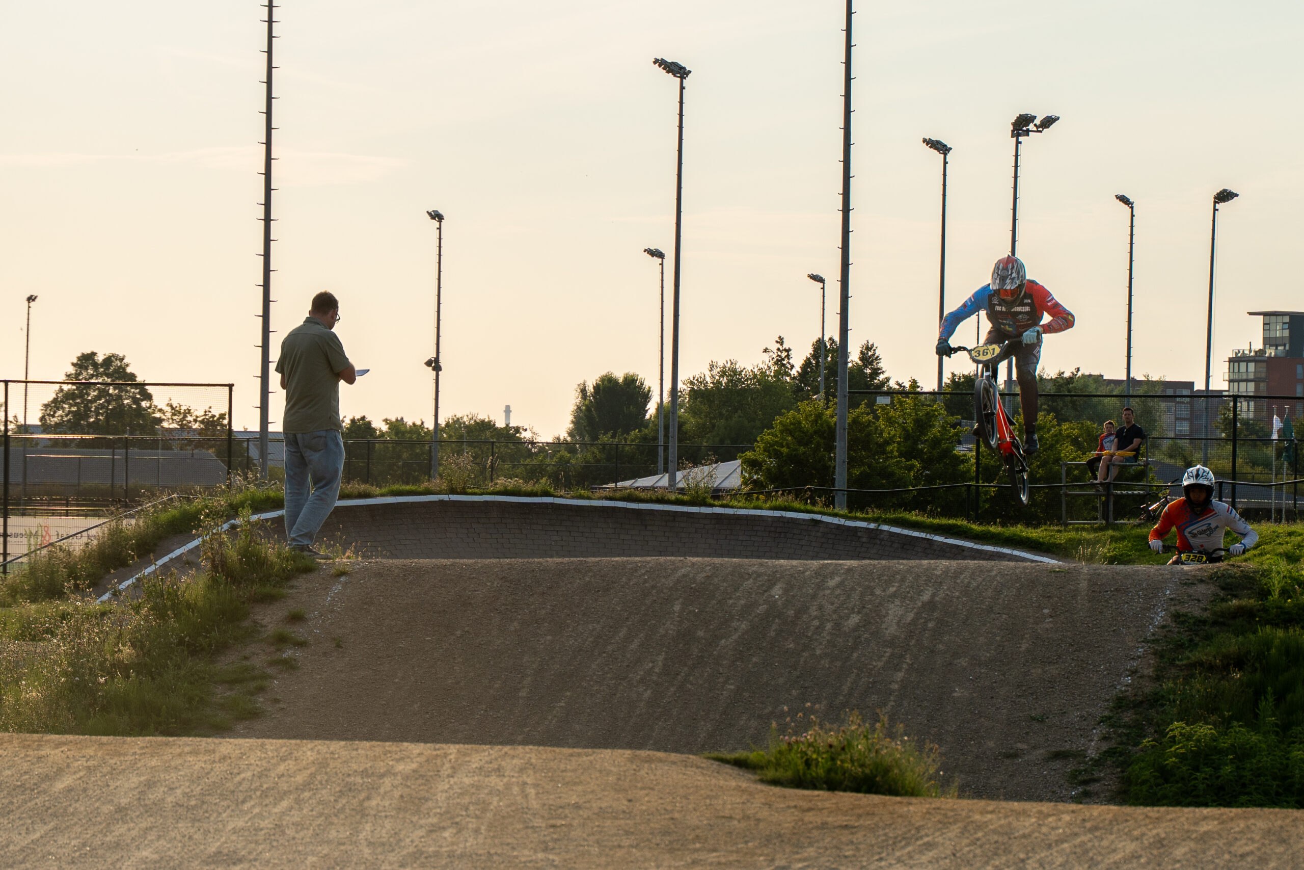 BMX-rijder maakt een sprong over een heuvel tijdens de wedstrijd.